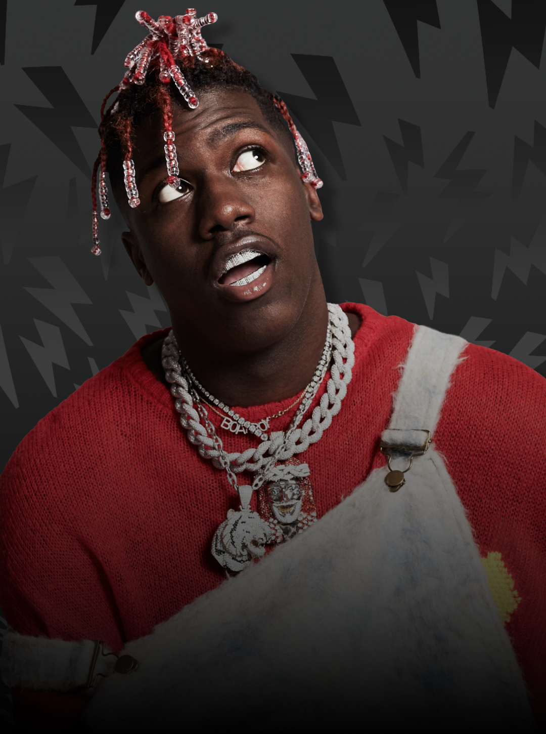 Person wearing a red sweater and overalls with a dark background